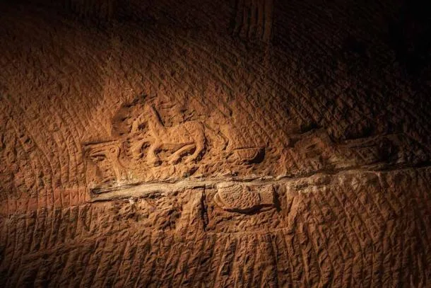 Escultura em relevo nas cavernas de Longyou, China, mostrando figuras de animais gravadas em pedra com padrões geométricos misteriosos.